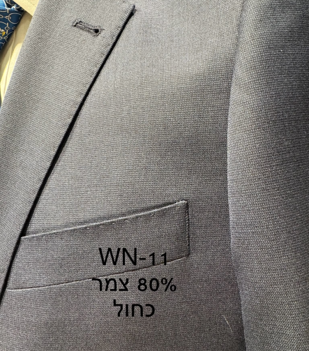 חליפת Adore דגם WN-11 בצבע כחול עם 80% צמר, צילום תקריב של דש הז'קט, כיס החזה ומרקם הבד