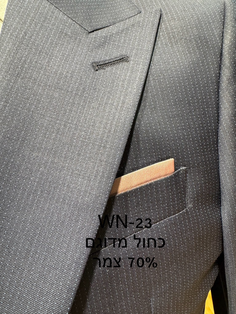 חליפת Adore דגם WN-23 בצבע כחול מדוגם עם 70% צמר, צילום תקריב של דש הז'קט, כיס החזה ומטפחת בגוון ורוד