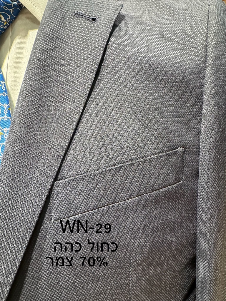 חליפת Adore דגם WN-29 בצבע כחול כהה עם 70% צמר ובד בעל מרקם גאומטרי עדין, צילום תקריב של דש הז'קט וכיס החזה
