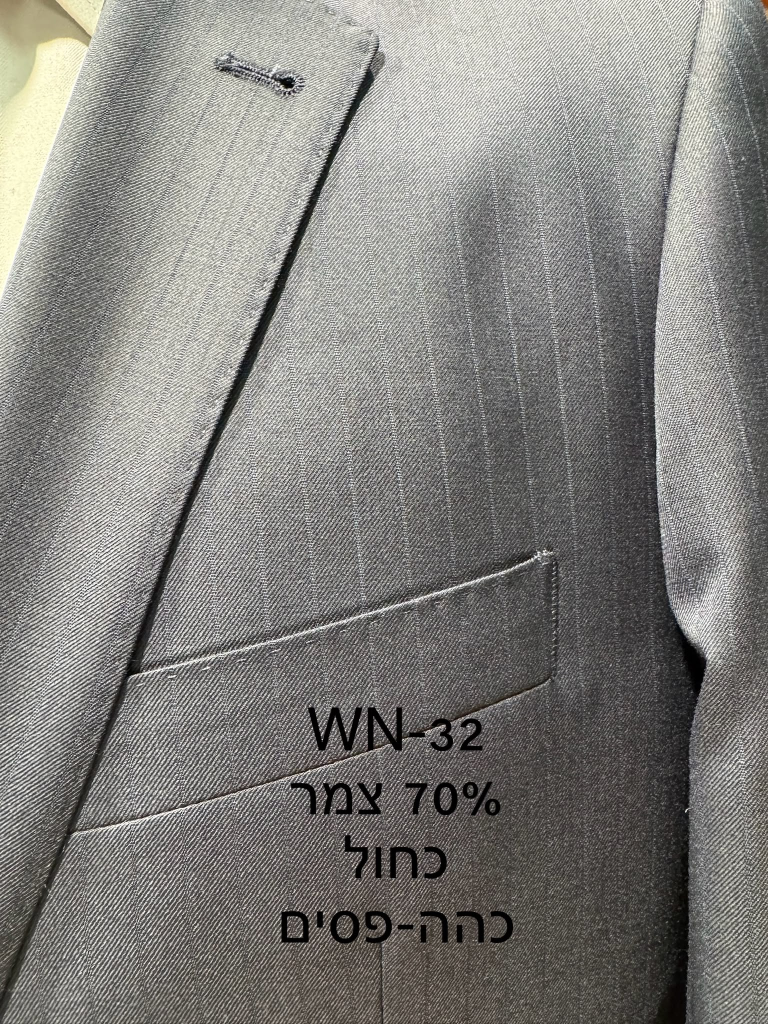 חליפת Adore דגם WN-32 בצבע כחול כהה עם פסי סיכה עדינים ו-70% צמר, צילום תקריב של דש הז'קט, כיס החזה ומרקם הבד