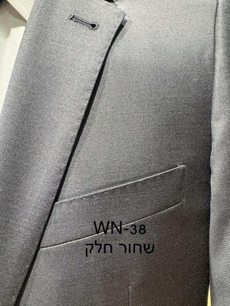 חליפת Adore דגם WN-38 בצבע שחור חלק, צילום תקריב של דש הז'קט, כיס החזה ומרקם הבד האחיד
