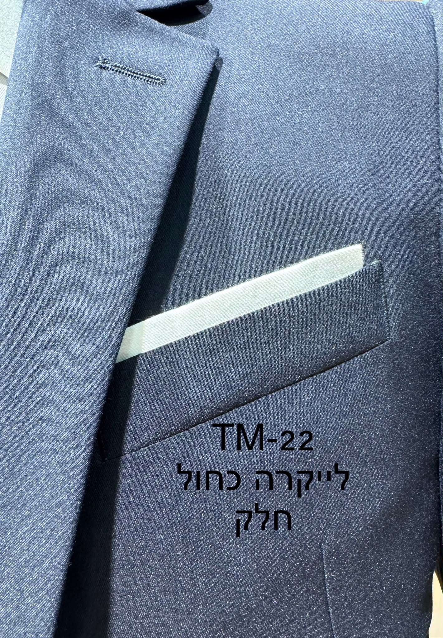 тм22 חליפת Adore דגם TM-22 בצבע כחול חלק מבד לייקרה, צילום תקריב של דש הז'קט, כיס החזה ומטפחת לבנה